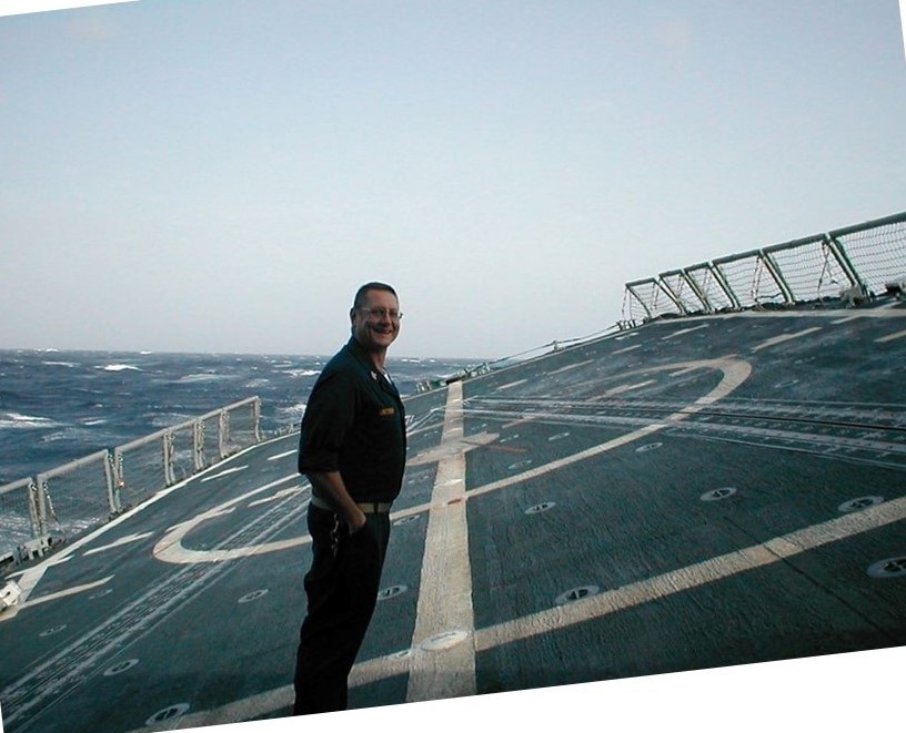Eric Jacobs smiling on the flight deck of a ship at sea